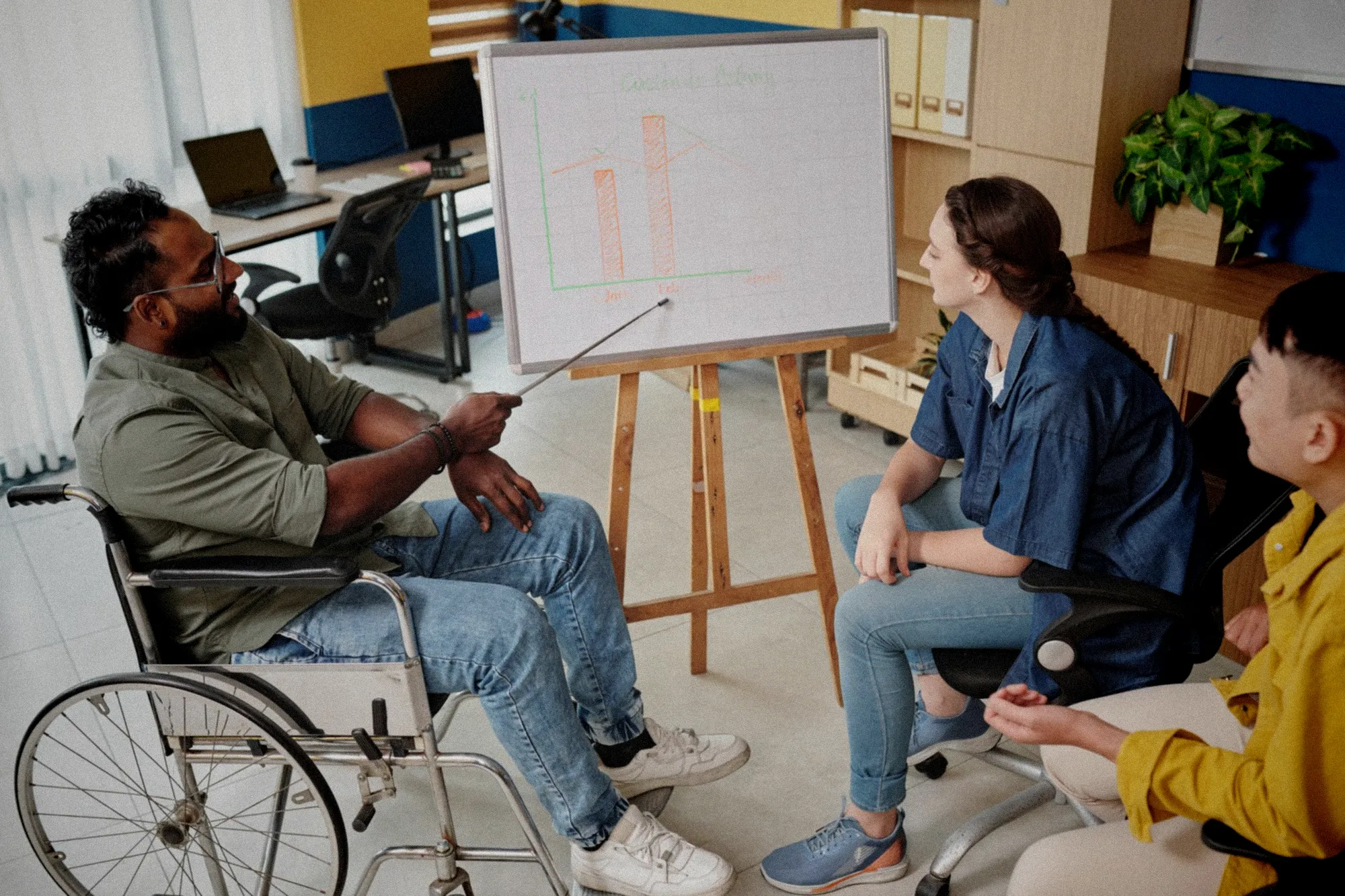 Groupe de personnes en situation de handicap travaillant ensemble dans un atelier créatif lumineux et accueillant