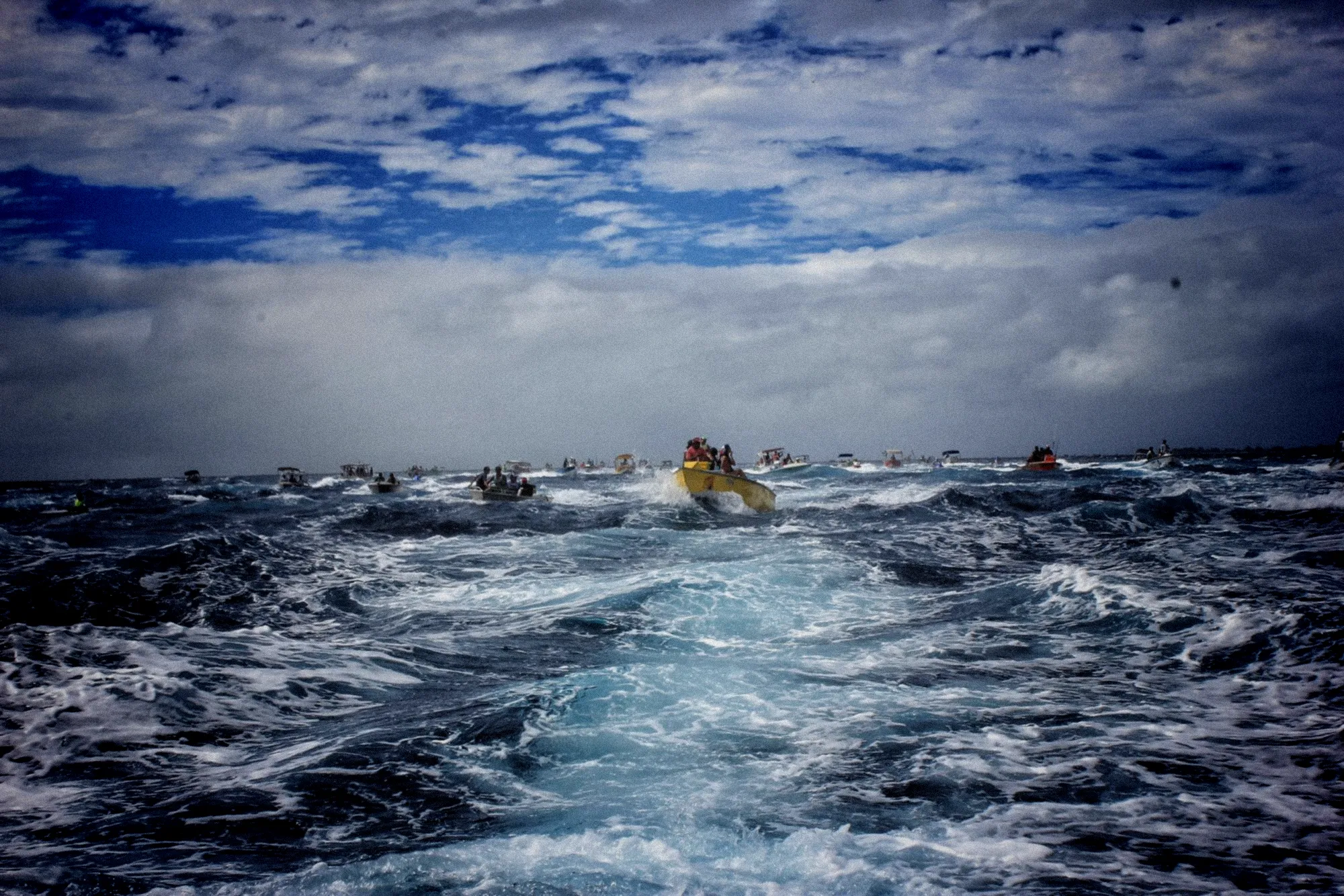 Bateau de pêche ancré dans le port, filets étendus, ciel menaçant et mer agitée