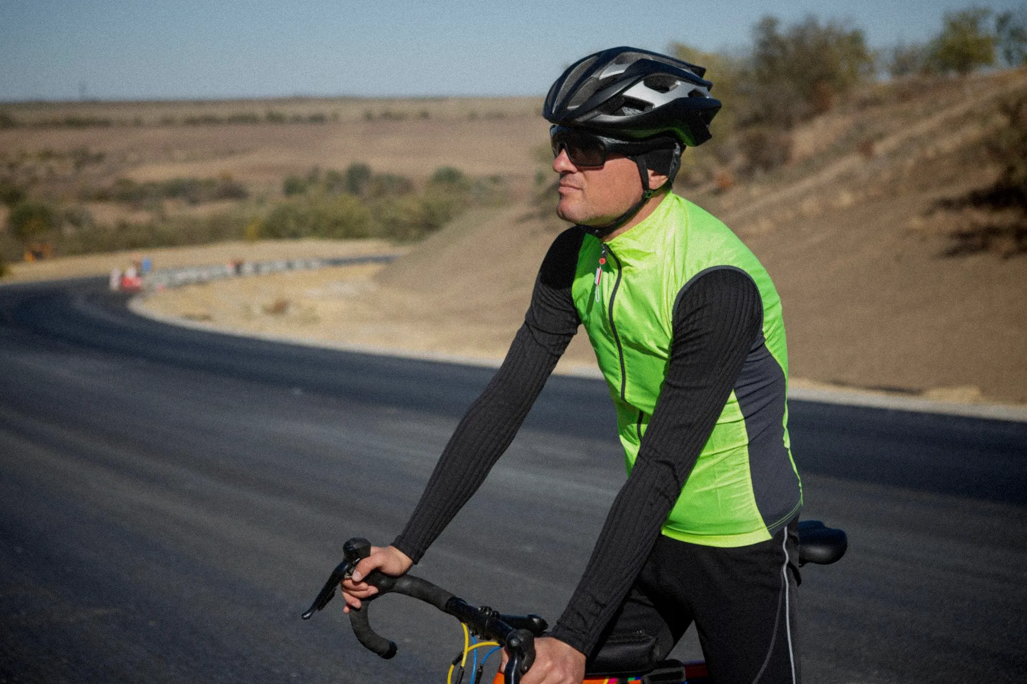 Un jeune cycliste en tenue d'équipe échange ses documents de signature face aux dirigeants souriants de son nouveau team professionnel