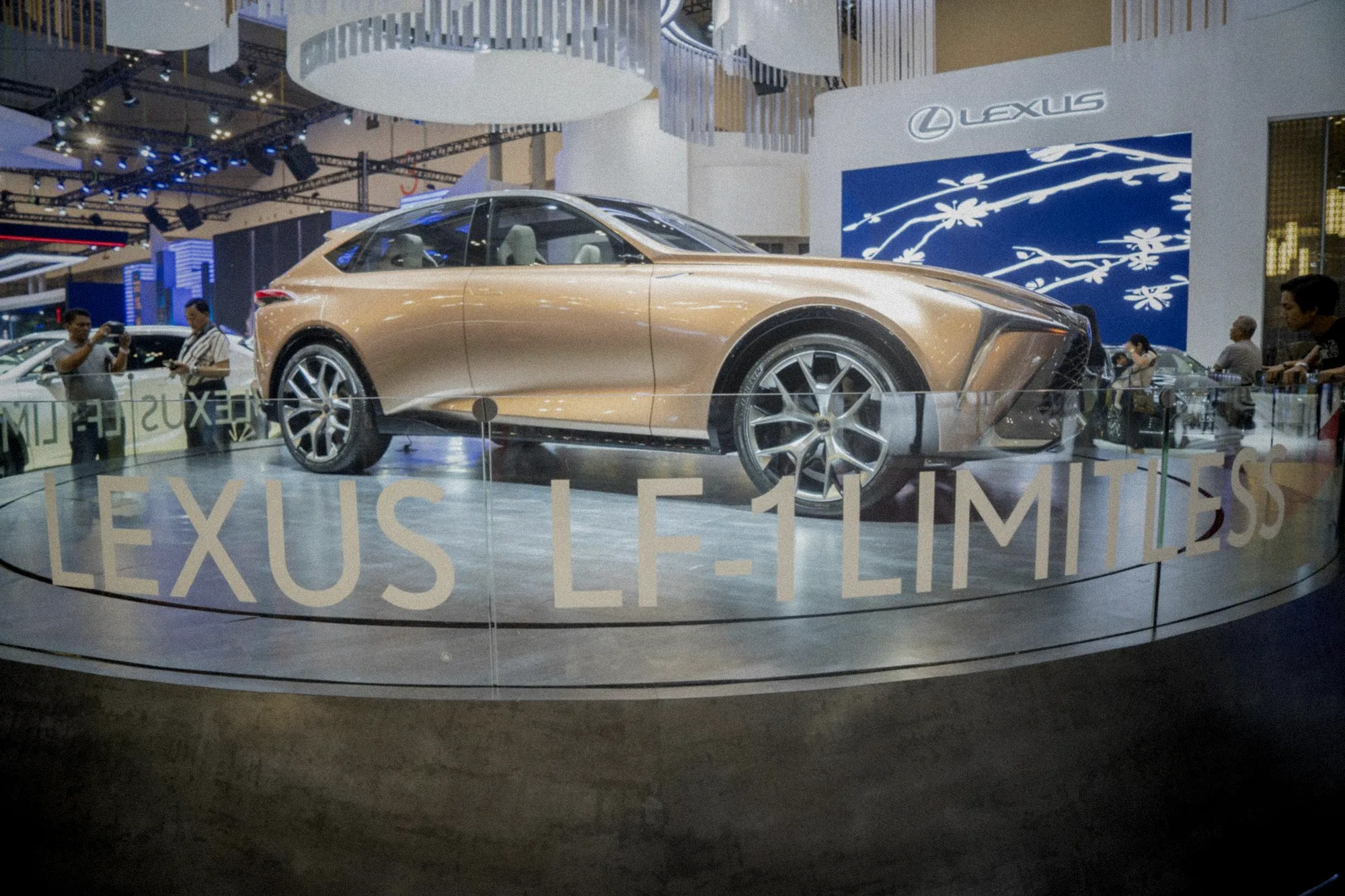 Pavillon automobile brillant avec visiteurs admirant voitures dernier modèle