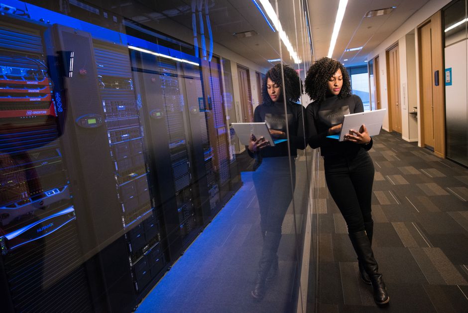 Homme face à écran lumineux, symboles de données numériques flottant autour, représentation de dépendance technologique