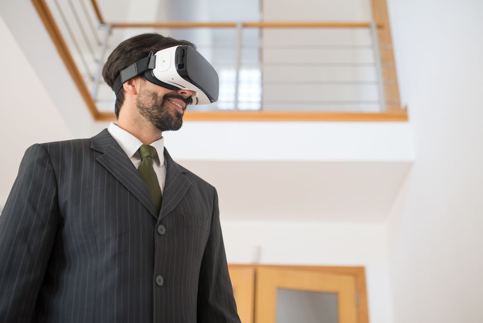 A confident businessman in a suit explores virtual reality indoors, symbolizing modern technology.