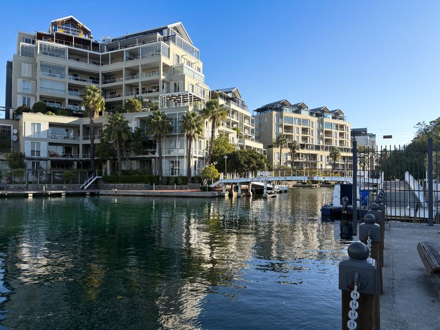 Scenic view of modern apartments at Cape Town waterfront with marina reflection.