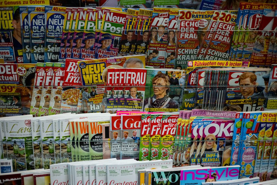 A vibrant display of magazines in a newsstand, showcasing various colorful covers and headlines.