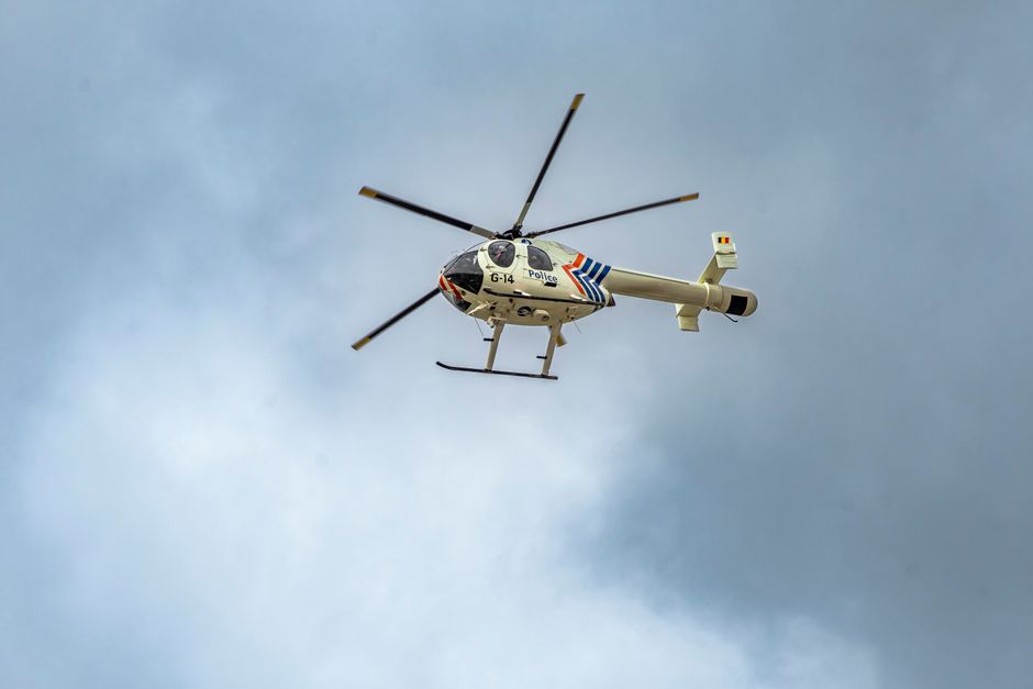 Police helicopter flying against a backdrop of dramatic clouds, showcasing aerial security and transportation.