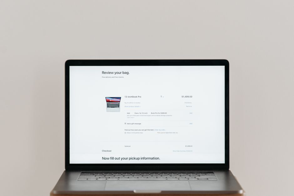 Minimalist laptop showing an online checkout screen on a white background, ideal for tech context.