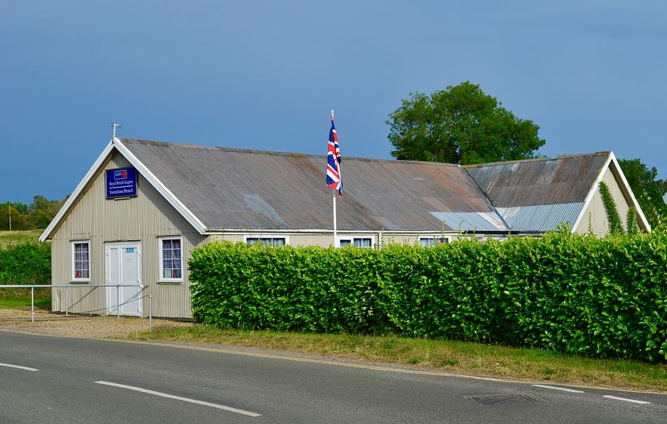 A British Legion building with a Union Jack flag on a sunny day.