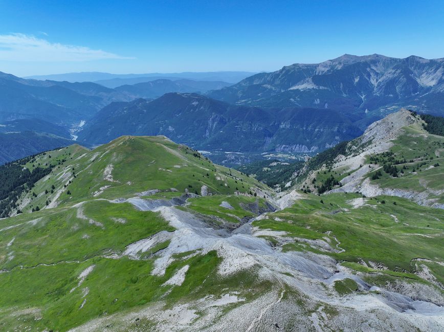 A breathtaking view of rugged mountains and lush green valleys in the French Alps.
