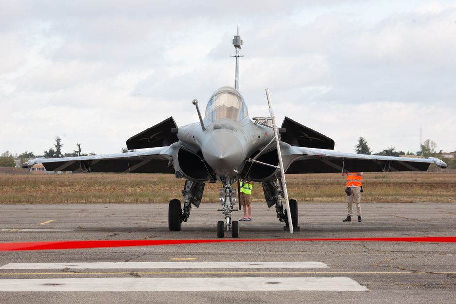 Front view of a Dassault Rafale fighter jet on the tarmac with technicians.