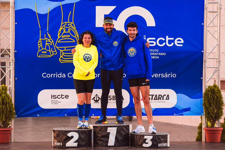 Three athletes on a podium celebrating a running event at ISCTE University.