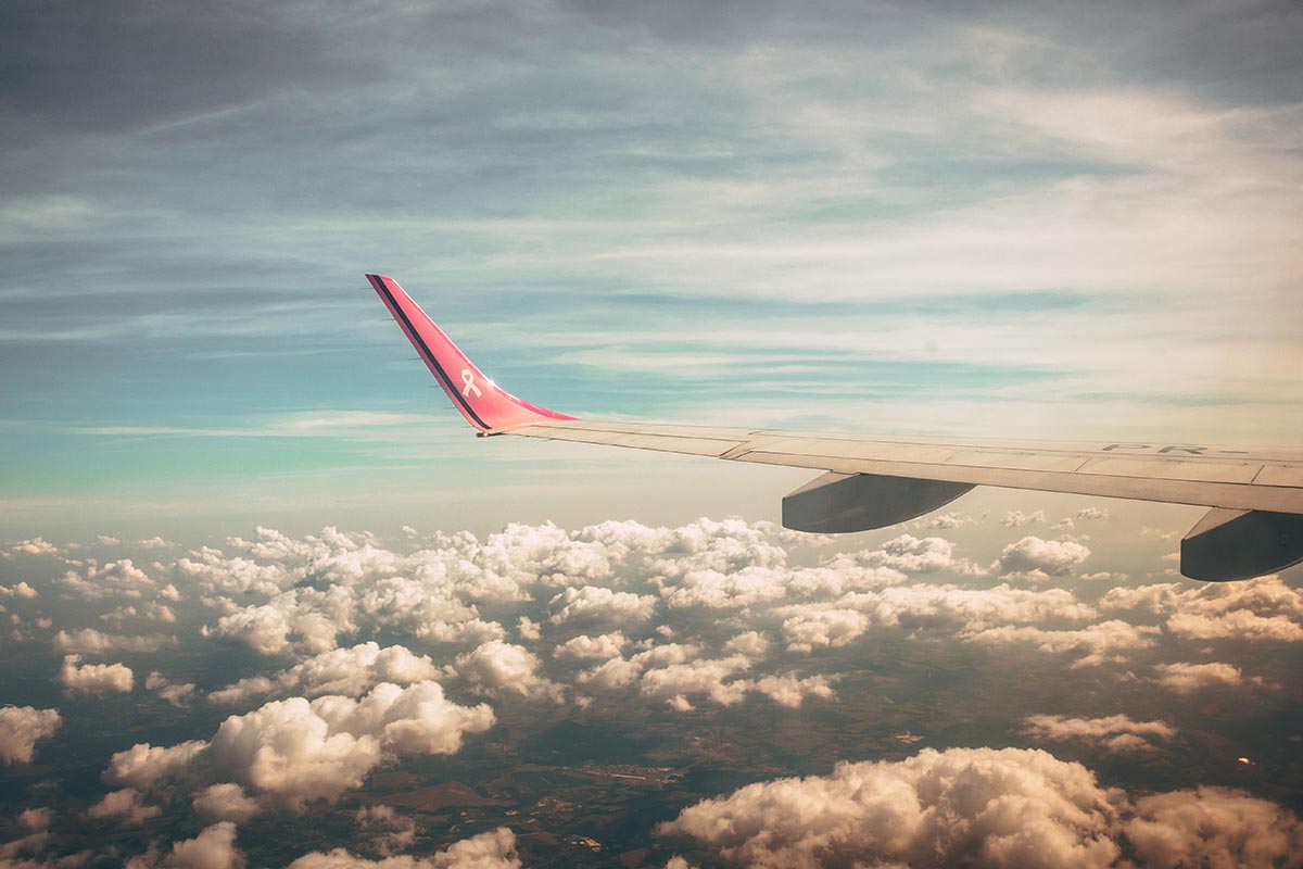 Vue depuis un hublot d’avion en plein vol au-dessus d’une épaisse couche de nuages