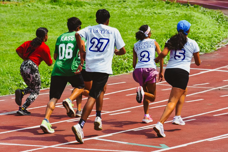 Young athletes compete in a vibrant relay race outdoors, showcasing speed and teamwork.