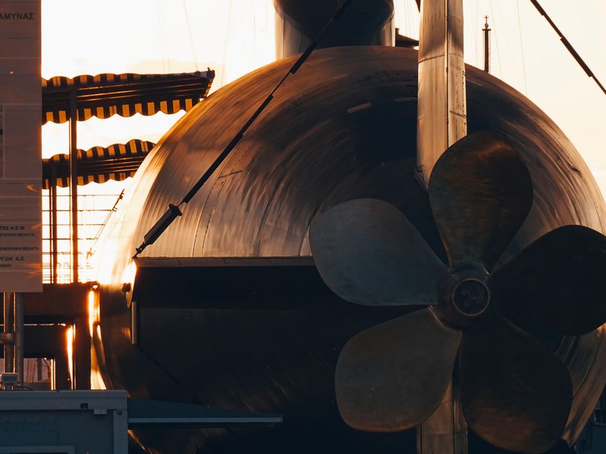 A striking image of a submarine propeller with sunlight reflecting off the surface, creating a dramatic effect.