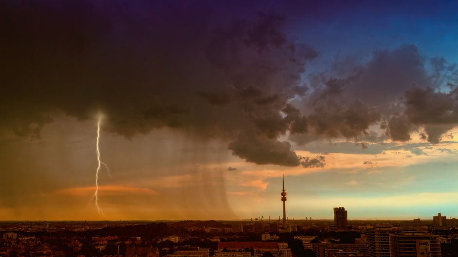 A powerful lightning storm captures the skyline as the sun sets, creating a dramatic urban scene.