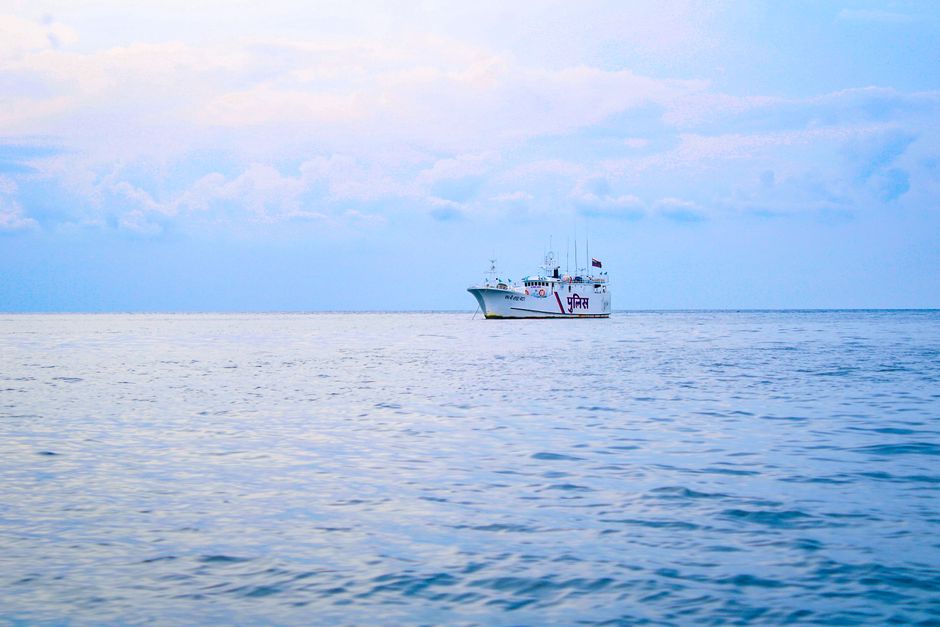 A serene scene of a coast guard vessel on the calm waters of the Indian Ocean under a clear sky.