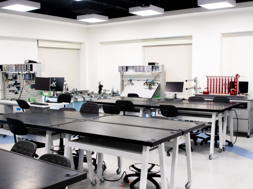 A contemporary classroom equipped with advanced technological tools and workstations.