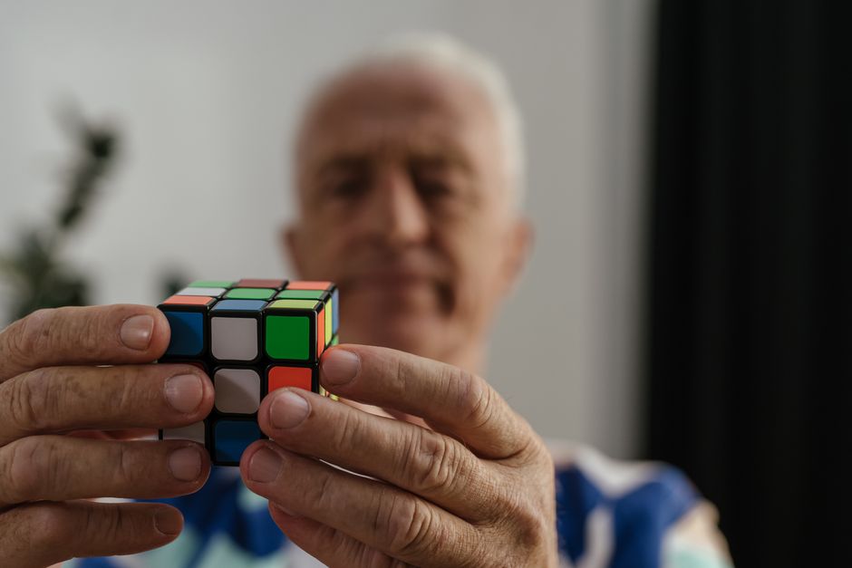 Un homme âgé résout un Rubik's Cube avec concentration