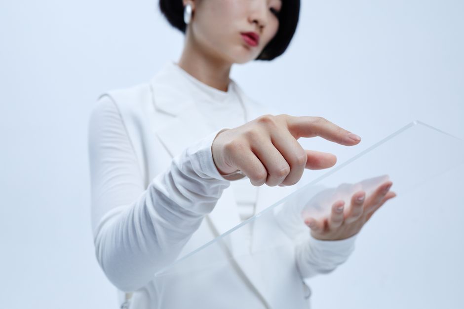 Une femme interagit avec une interface transparente en environnement futuriste.