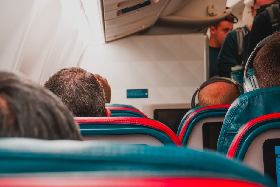 Intérieur d'une cabine d'avion avec rangées de sièges passagers.