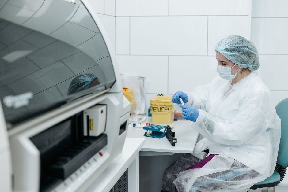 Chercheur en tenue de protection analysant des échantillons en laboratoire