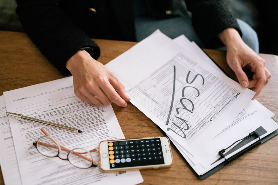 Personne examinant des documents fiscaux avec une calculatrice