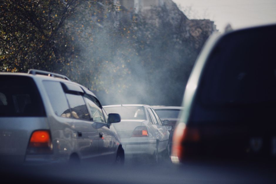 Embouteillage urbain avec voitures émettant de la pollution sur une route chargée.