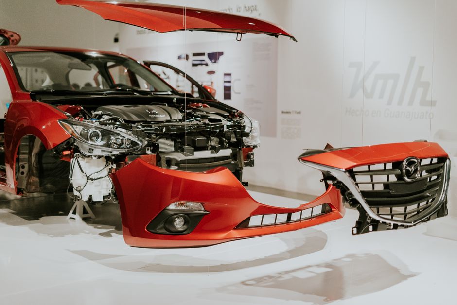 Vue détaillée d'une Mazda 3 rouge partiellement démontée lors d'une exposition automobile