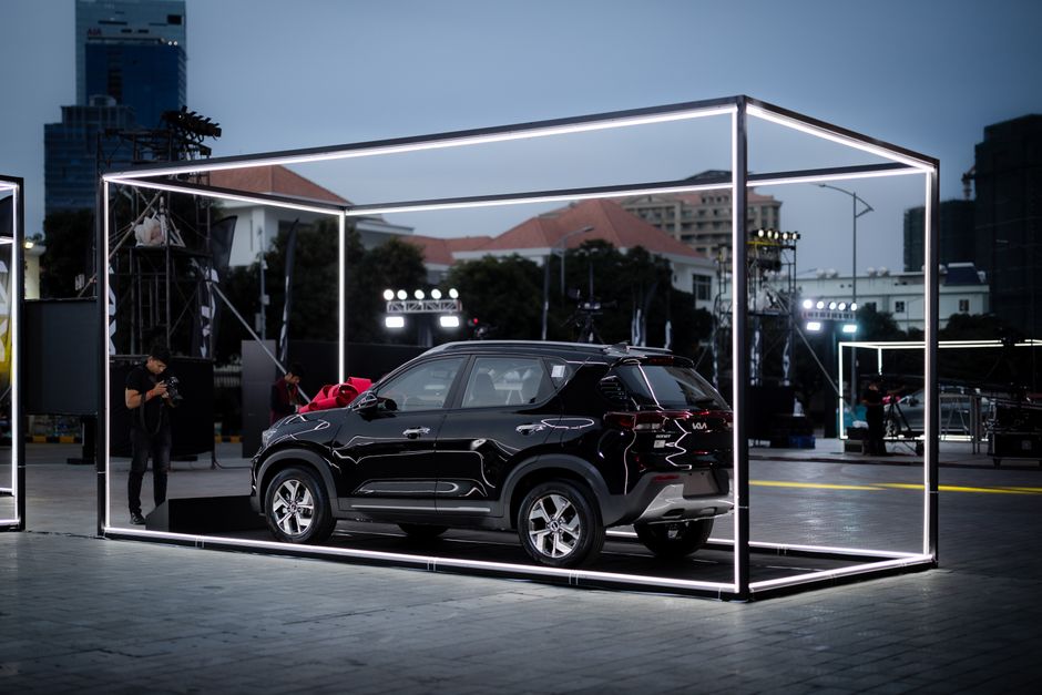 Voiture noire présentée dans un cadre illuminé en extérieur
