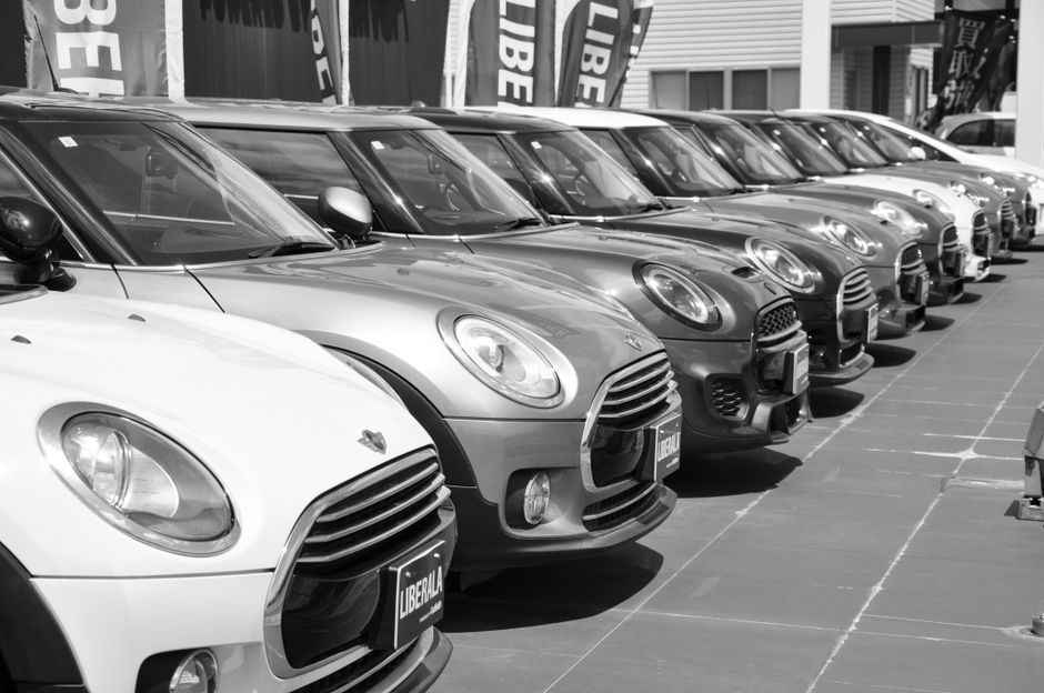 Une rangée de voitures compactes stationnées dans un showroom automobile.