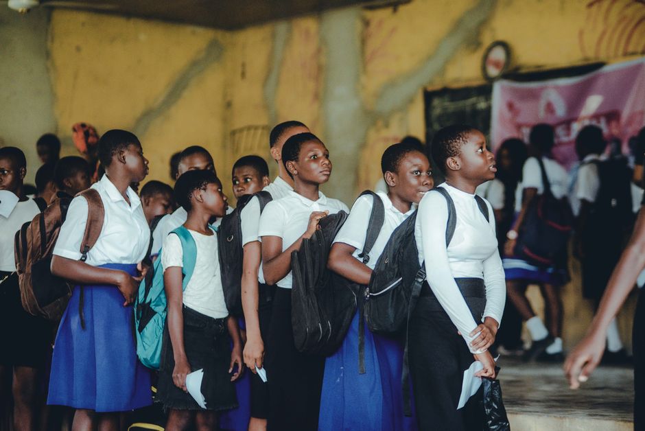 Des enfants en uniforme scolaire attendent en file d'attente.
