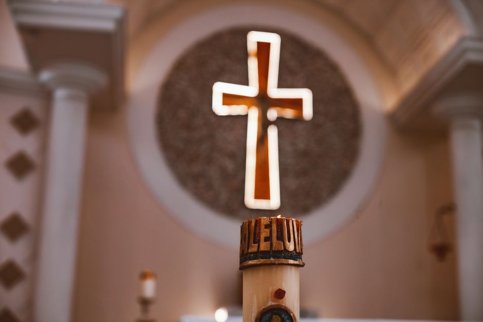 Une croix lumineuse au-dessus d'une bougie dans une église