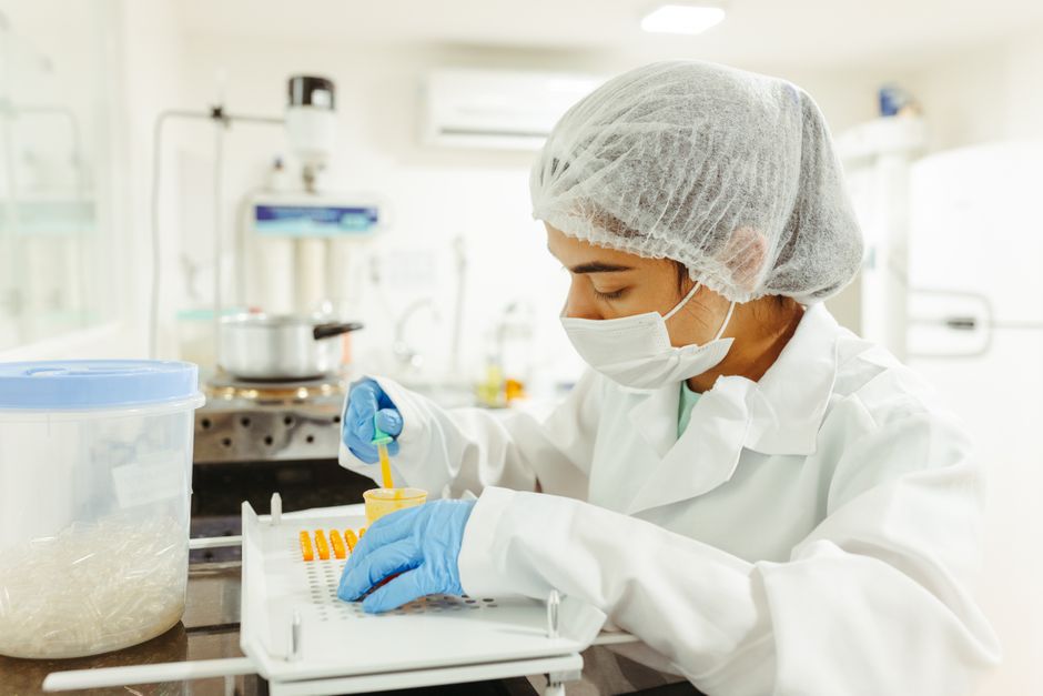 Un scientifique en tenue de protection réalise une expérience en laboratoire.