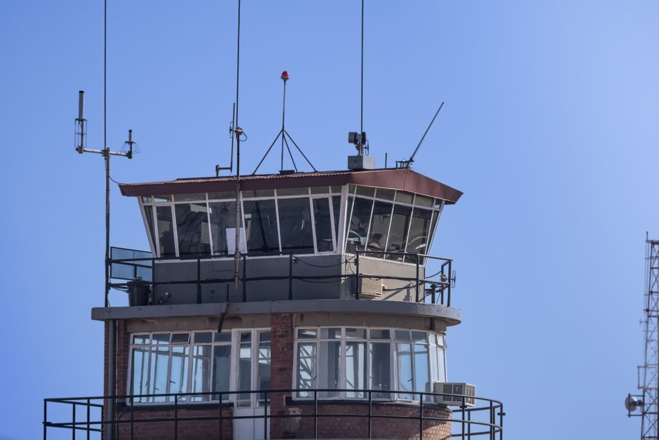 Une tour de contrôle aéroportuaire moderne sous un ciel bleu dégagé