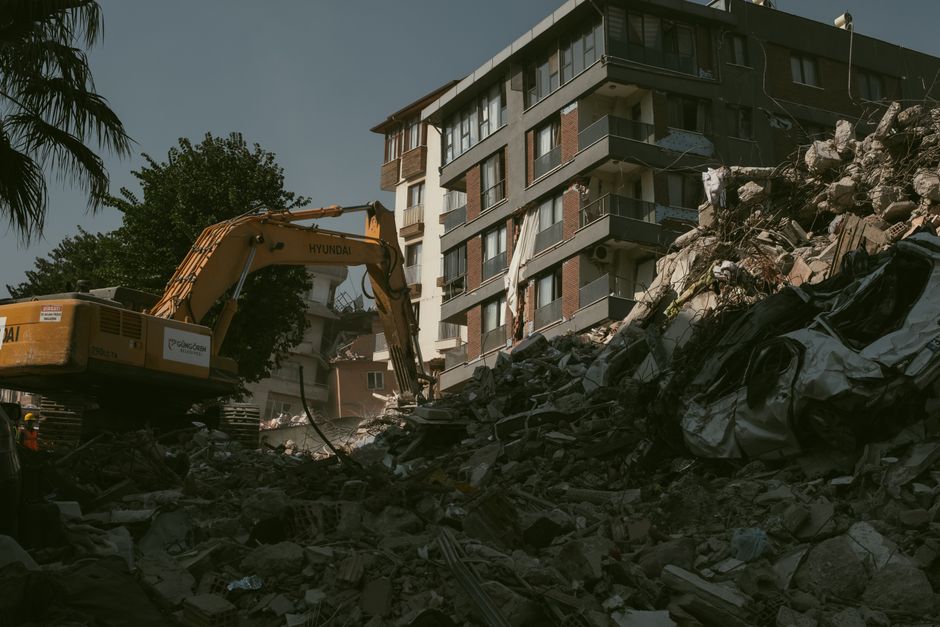 Débris d'effondrement de bâtiment évacués par une pelle mécanique