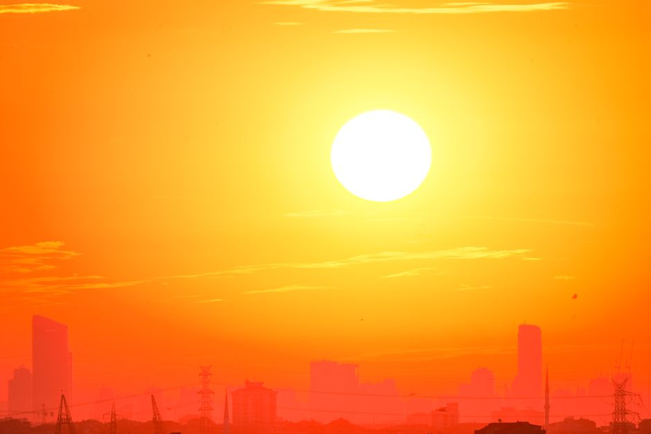 Silhouette de bâtiments urbains contre un ciel orange au coucher du soleil
