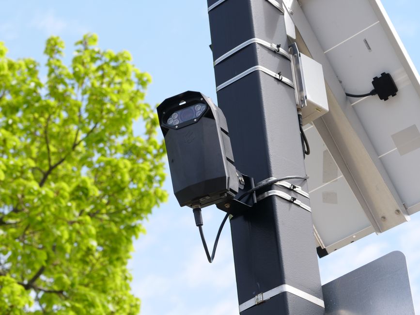 Caméra de surveillance moderne montée sur un poteau urbain.