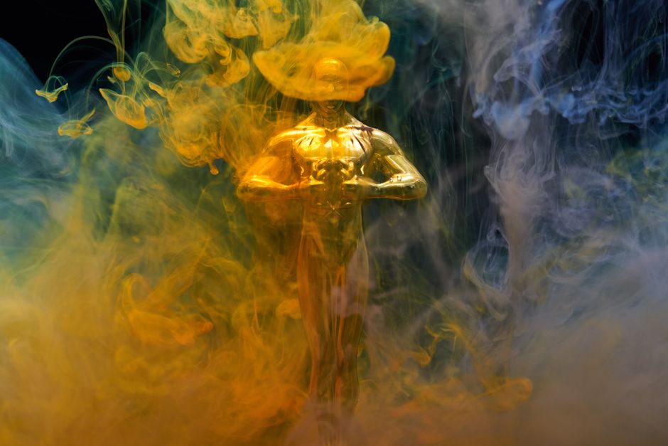 Une statuette dorée entourée de fumée bleue et jaune