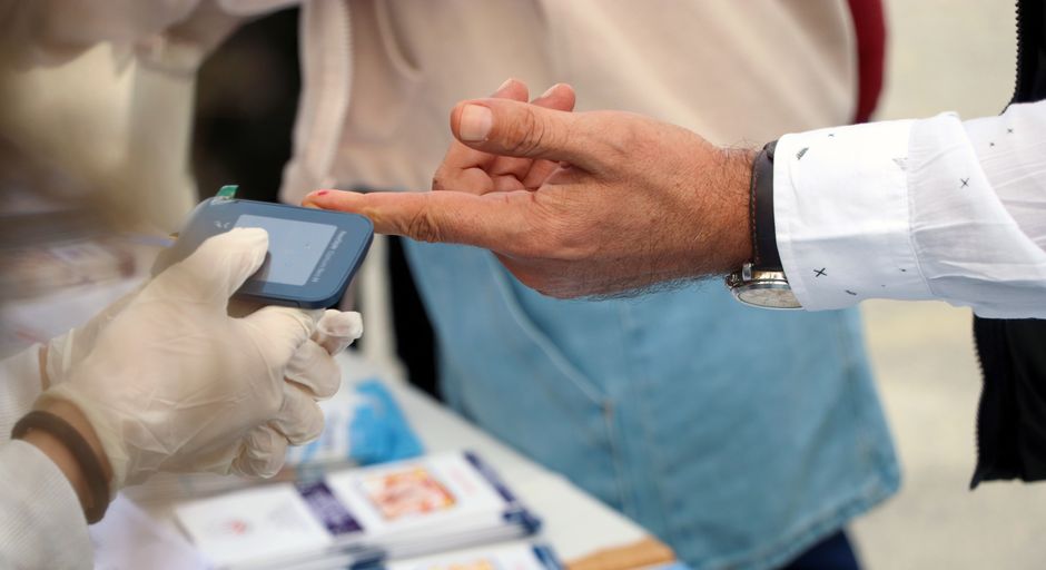 Un professionnel de santé mesure la glycémie d'une personne lors d'un dépistage.