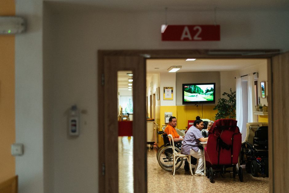 Aide-soignante accompagnant une personne âgée dans un couloir d'établissement