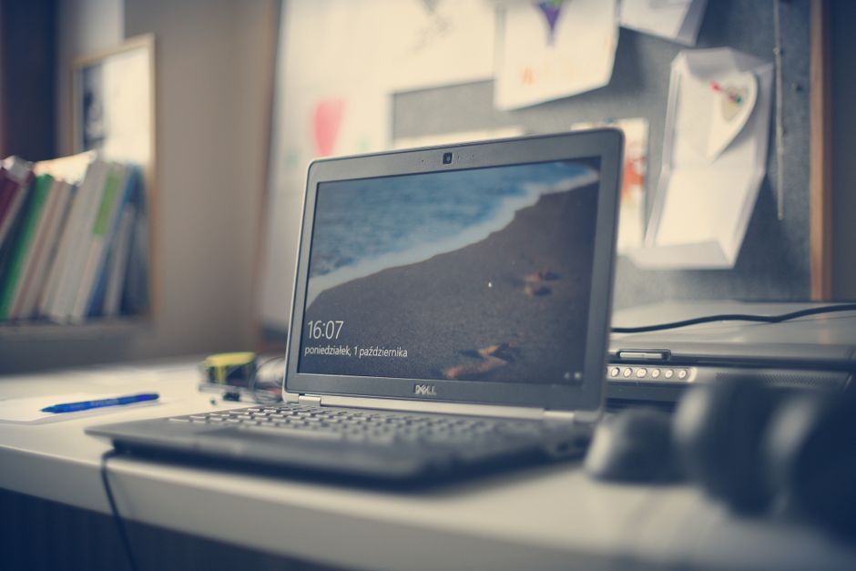 Un ordinateur portable sur un bureau avec des livres et du matériel de bureau.
