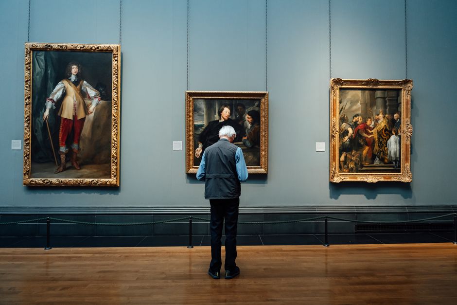 Un homme admire des peintures classiques dans une galerie d'art anglaise