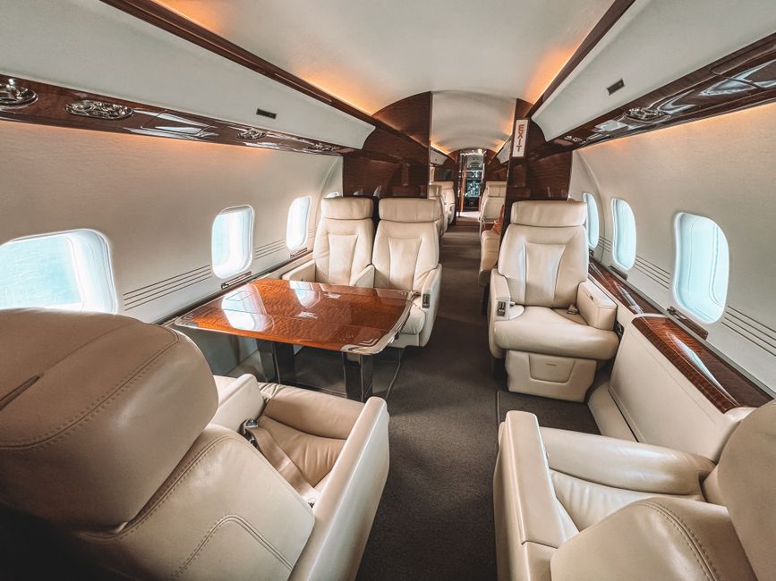Intérieur d'un avion privé avec sièges en cuir et boiseries.