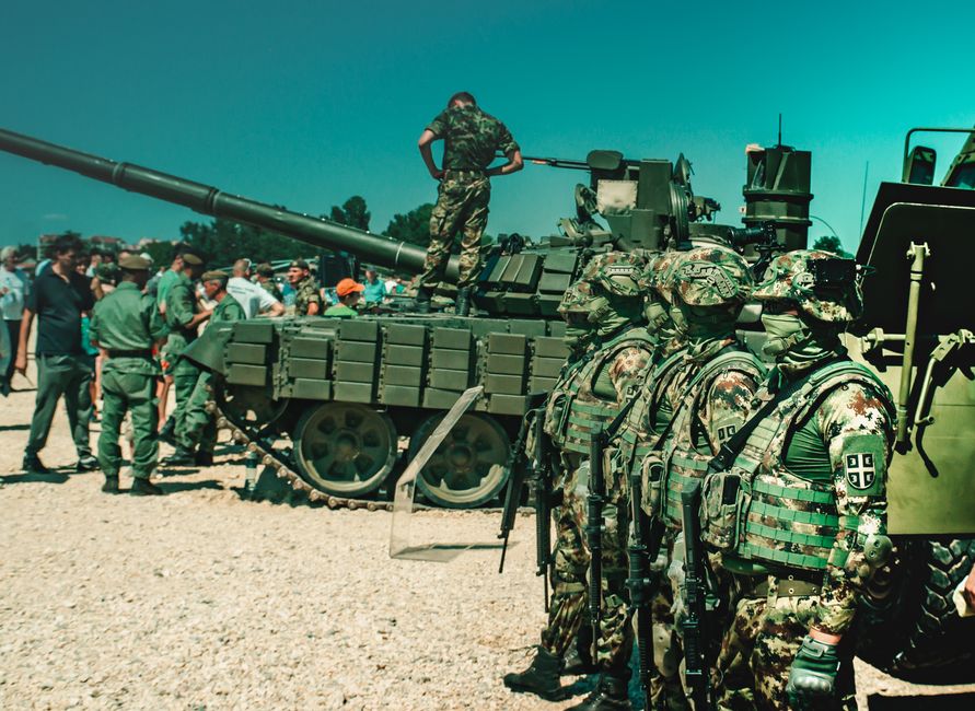 Soldats en tenue de camouflage près d'un char lors d'un exercice d'entraînement