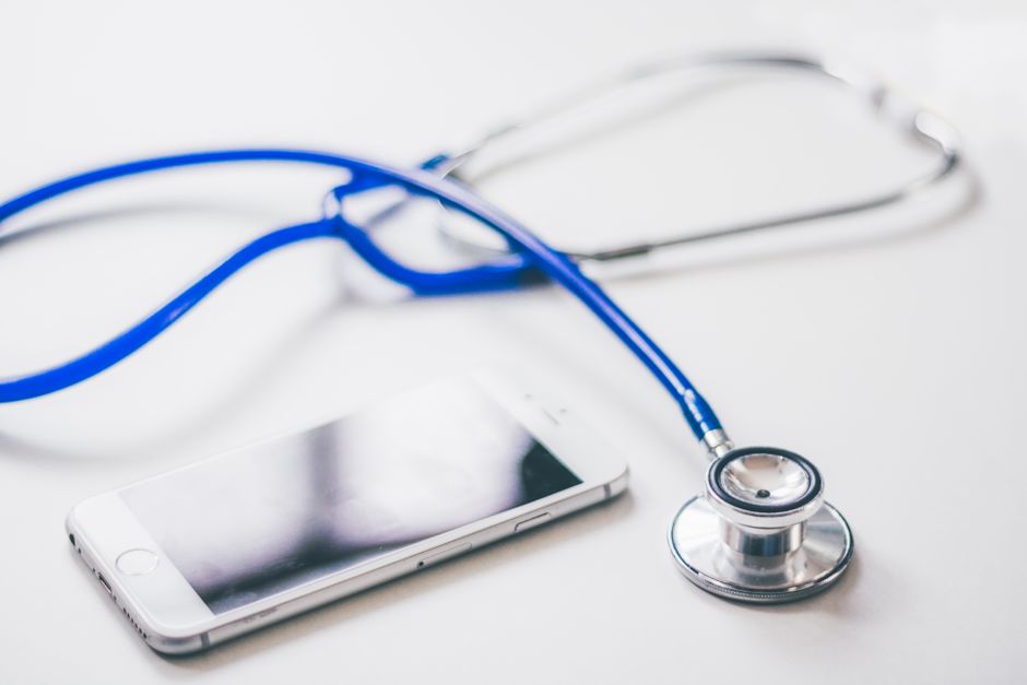 Un téléphone et un stéthoscope bleu sur fond blanc