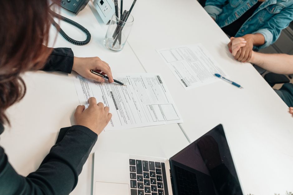 Deux personnes échangent des documents à un bureau de travail