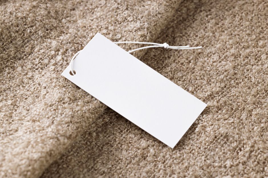 Étiquette de prix blanche vierge sur tissu beige texturé