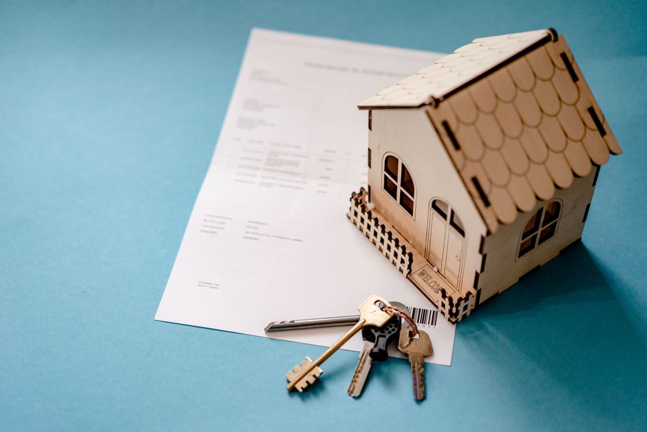 Petite maison en bois avec clés et contrat immobilier