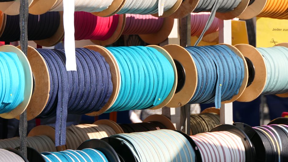 Des bobines colorées de ruban textile posées côte à côte
