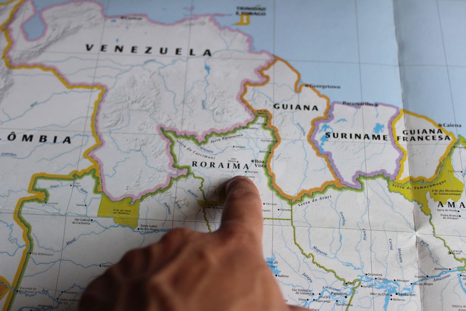 Doigt pointant une région sur une carte détaillée du Brésil
