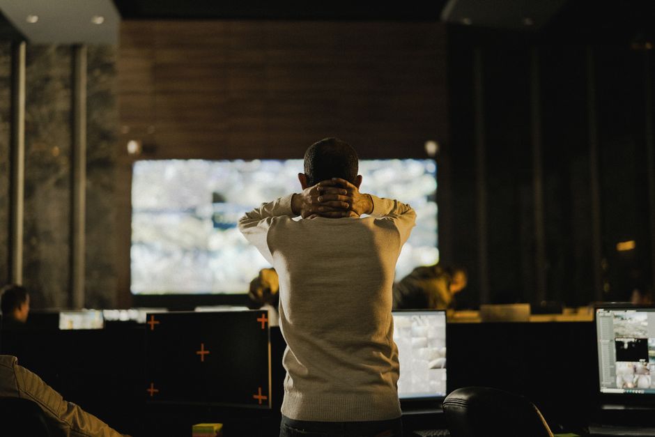 Un homme observe des écrans dans une salle de contrôle